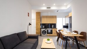 Een modern appartement met een woongedeelte, een eethoek en een kitchenette.