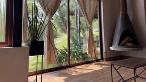 A room with large windows, a fireplace, and a potted plant. - Cabañas Santa Fe Tapalpa (Tapalpa)