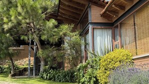 A rustic building with a tiled roof, large windows, and a chimney. - Cabañas Santa Fe Tapalpa (Tapalpa)