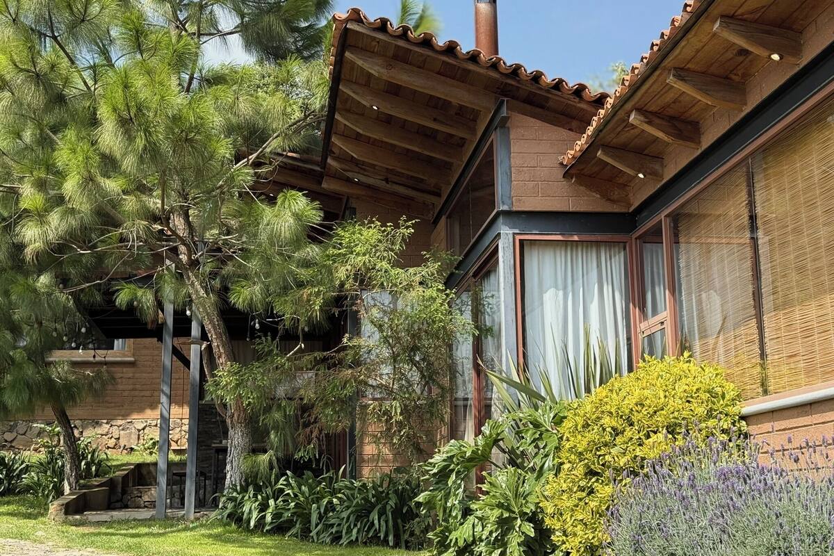Un bâtiment de style rustique, doté d’un toit en tuiles, de grandes fenêtres et d’une cheminée.