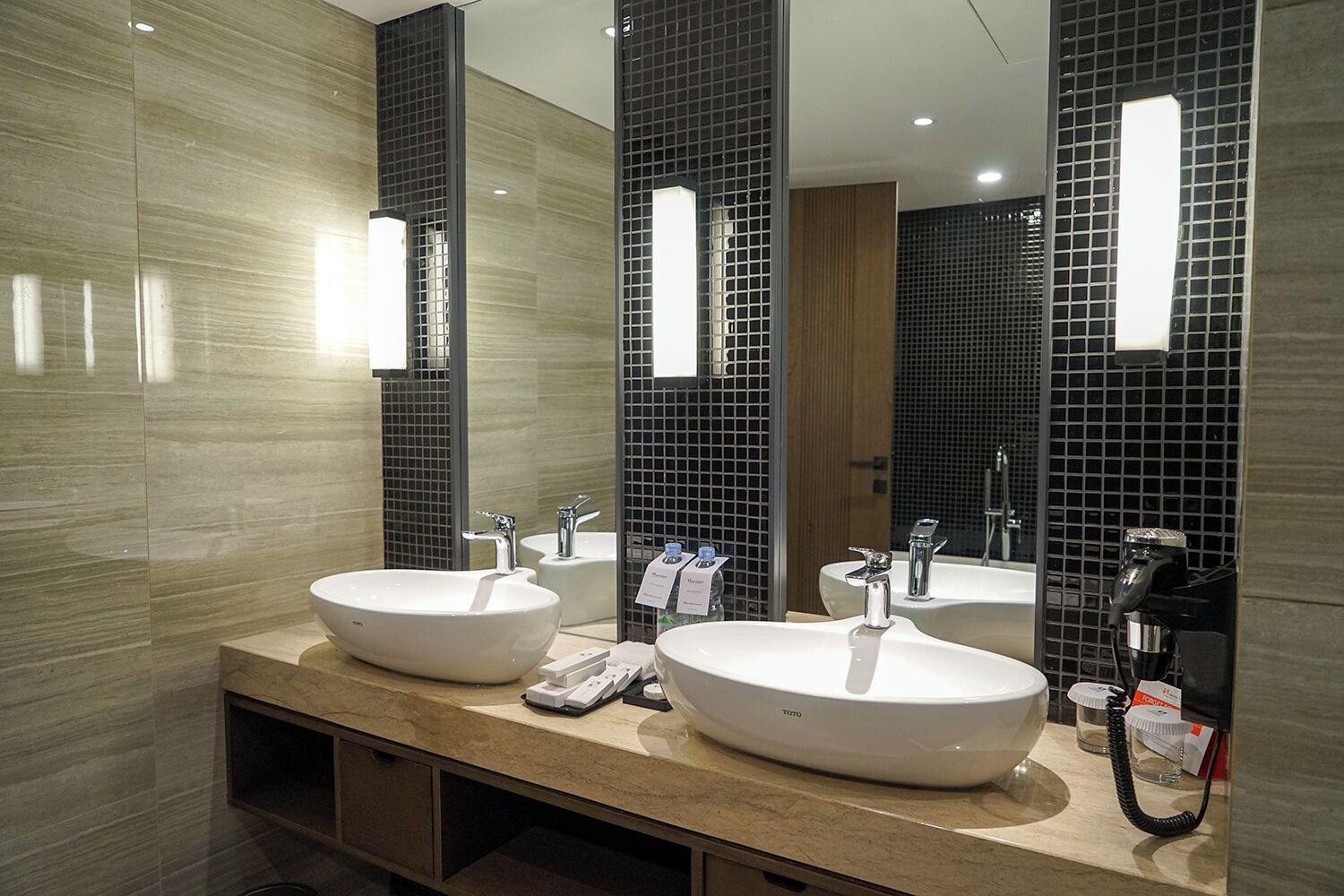 Een moderne badkamer met twee grote wasbakken, een spiegel en een wastafelmeubel met een aanrechtblad.