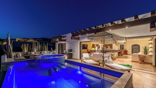 A modern outdoor pool area with a hot tub, lounge chairs, and a well-lit patio. - Villa Cactus (Cabo San Lucas)