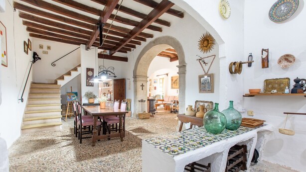 A rustic interior with a staircase, a dining area, and a kitchen. - 'Ca'n Pont' with Mountain Views, Private Pool and Wi-Fi (Illes Balears)