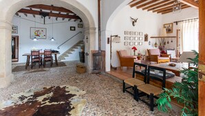 A rustic interior with a stone floor, wooden furniture, a staircase, and a dining area. - 'Ca'n Pont' with Mountain Views, Private Pool and Wi-Fi (Illes Balears)