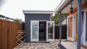 A modern house with a patio area featuring a herringbone tile floor and a wooden fence. - Anrym #1 - by Zenbreak (St. Lawrence Gap)