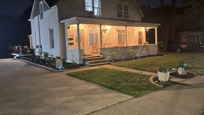 A two-story house with a covered front porch and a well-maintained lawn. - Lovely 2 BR 2BA, Close to Mayo and trails (Rochester)