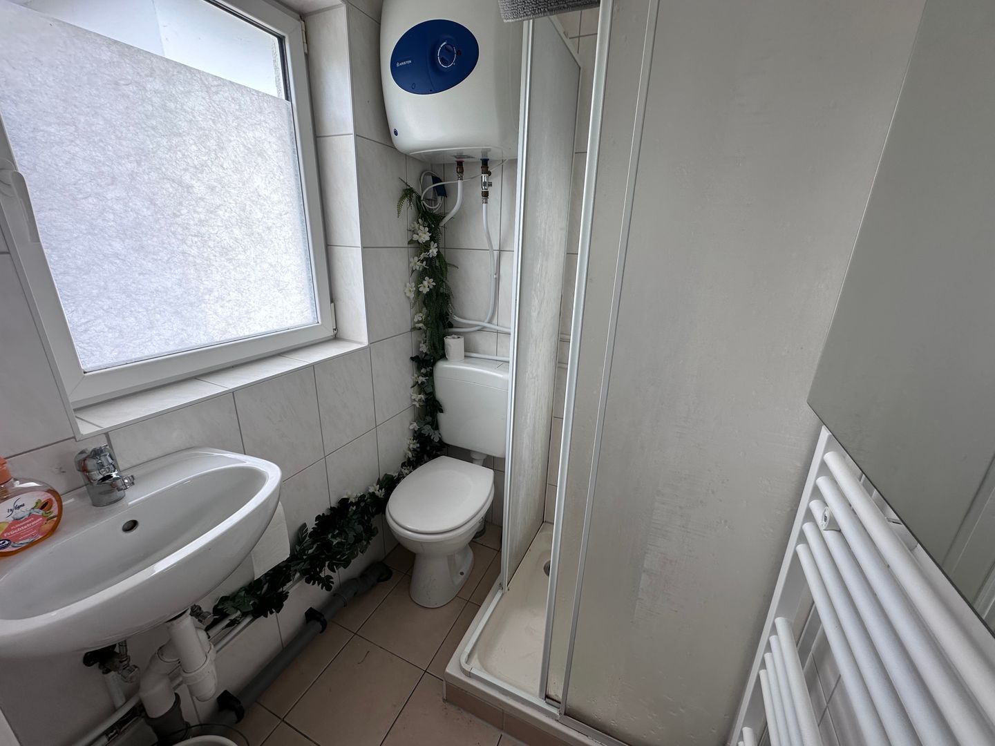 Un baño con lavamanos, inodoro y ducha.