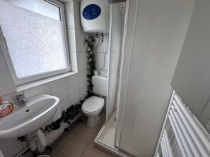 A bathroom with a sink, toilet, and shower.