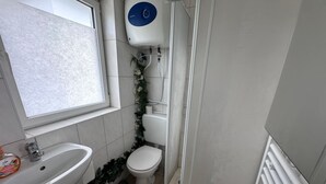 Ein Badezimmer mit Waschbecken, Toilette und Dusche.