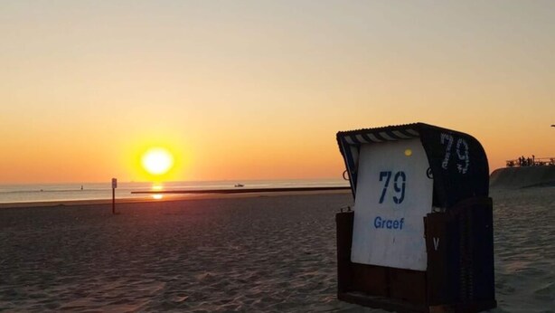 Een strandlocatie met een weerstation dat een temperatuur van 79 graden aangeeft.