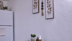 A modern kitchen with a black table, a beige tablecloth, and framed artwork on the wall. - Cozy 2-bedroom mobile home in lovely Encampment with AC, WiFi (Encampment)