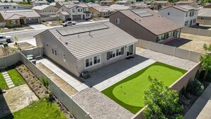 Un quartier résidentiel avec des maisons, une pelouse verdoyante et une chaîne de montagnes en arrière-plan.