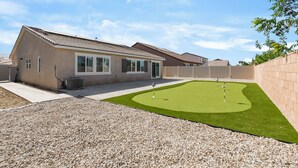Il s’agit d’une propriété résidentielle comprenant une maison, une cour arrière avec une pelouse artificielle et une allée gravillonnée.