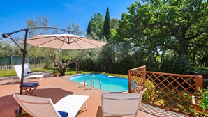 Zona junto a la piscina con sillas de descanso y una piscina.