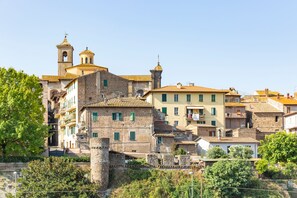 A historic town with stone buildings, a bell tower, and a fortified wall.