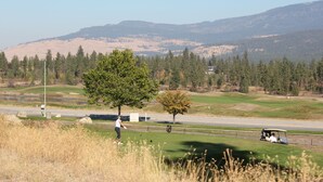 Camp de golf amb una vista despejada del paisatge circumdant, incloent-hi turons i arbres.