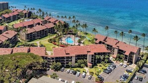 A resort with multiple buildings, a swimming pool, and a view of the ocean. - SUMMER SALE! Remodeled Condo w Ocean Views Pool AC - Papakea  J106 (Lahaina)