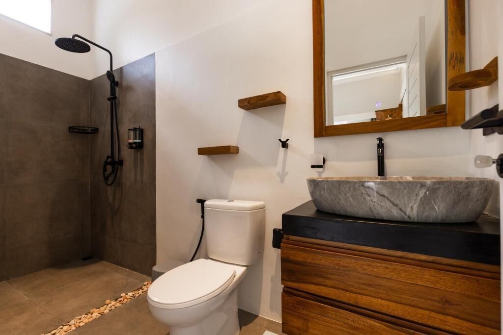 Un baño moderno con ducha, inodoro y tocador.