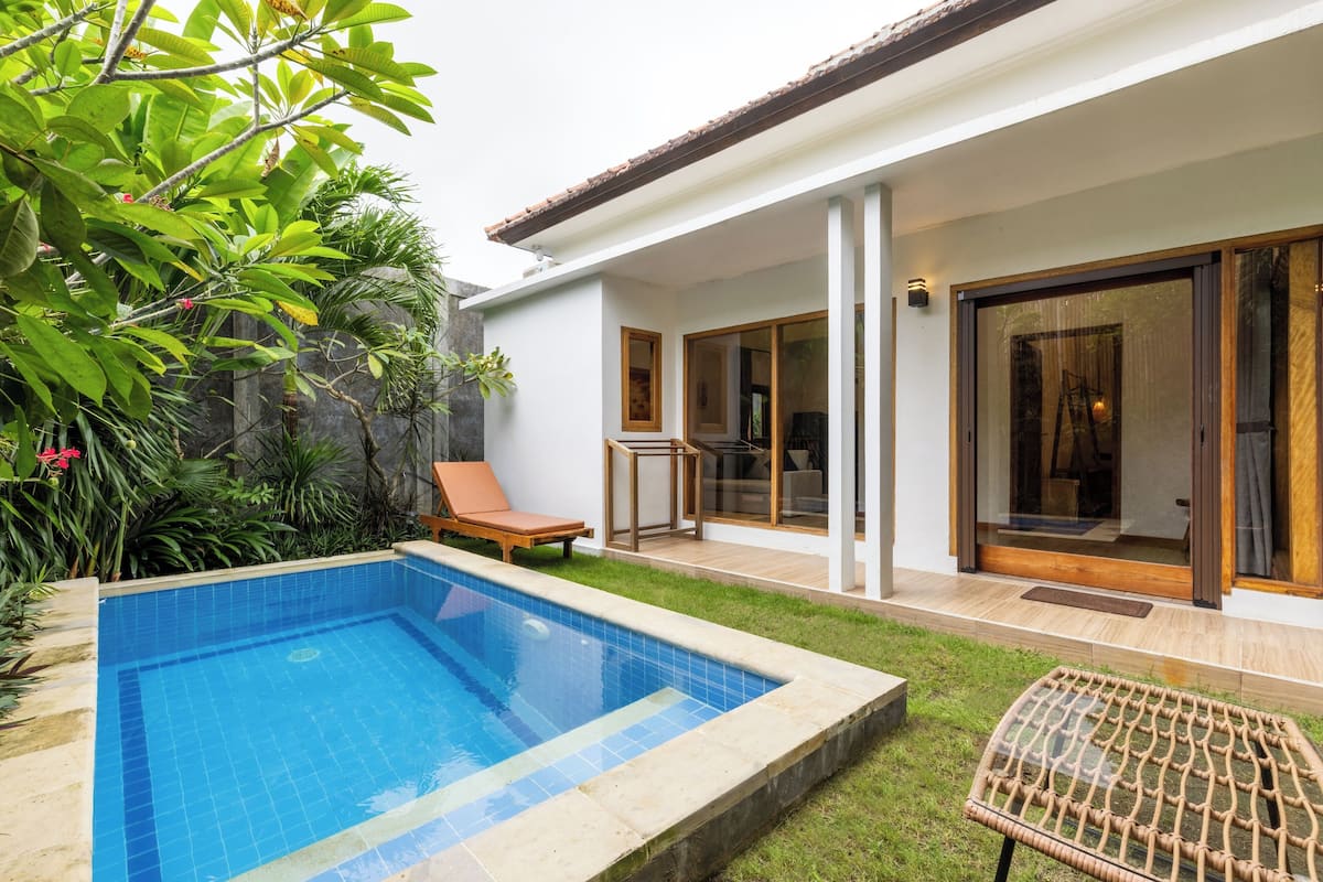 A modern house with a swimming pool, a covered patio, and a large sliding glass door.