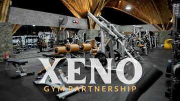 A gym with various exercise equipment, including weight machines and benches.