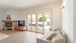 Un salon avec une cheminée, un téléviseur et un canapé.