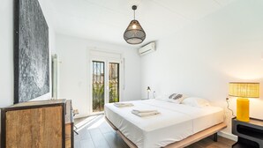Une chambre à coucher avec un lit, une table de chevet et une lampe.