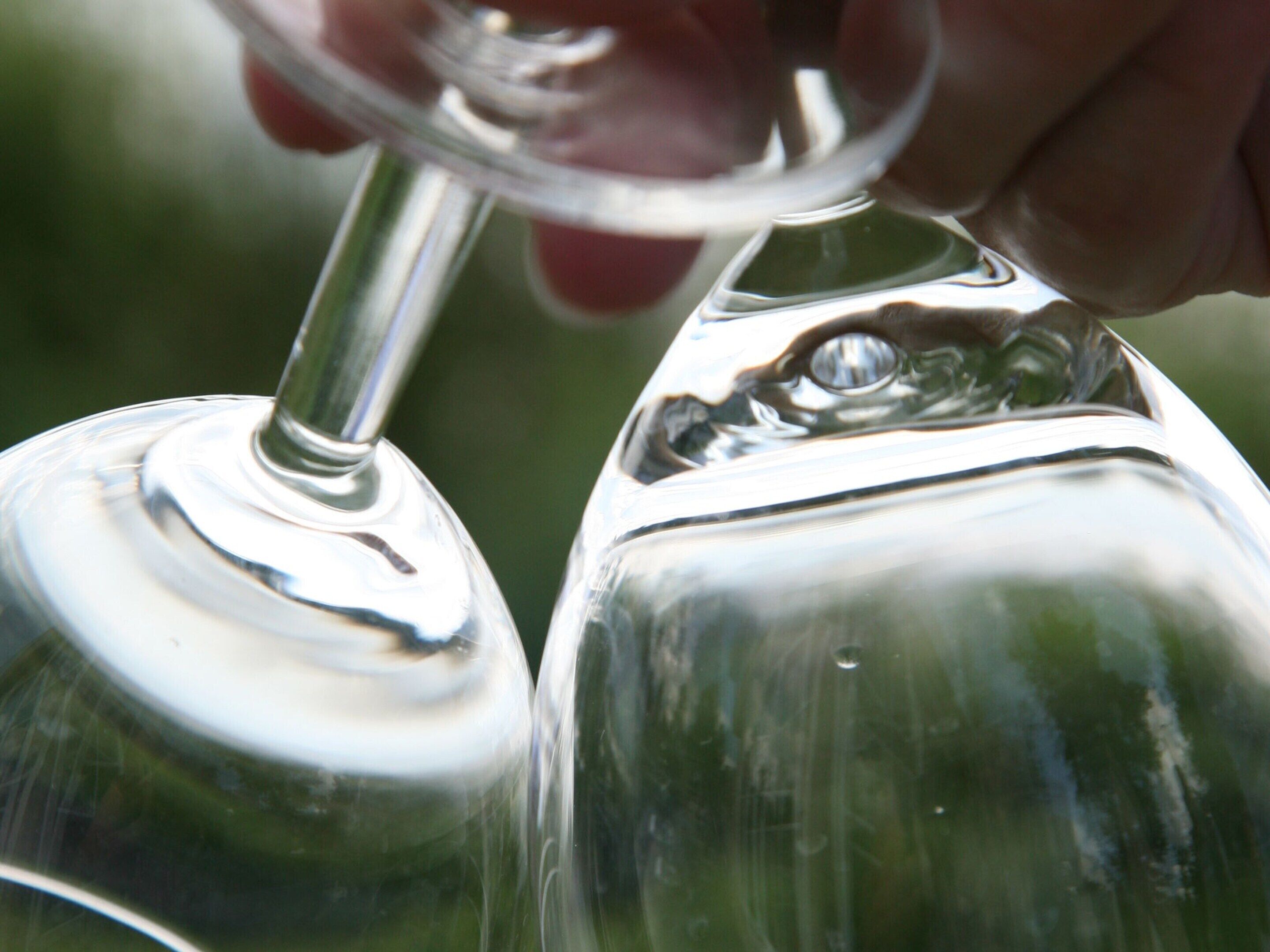 A close-up of a hand holding a wine glass with a stem.