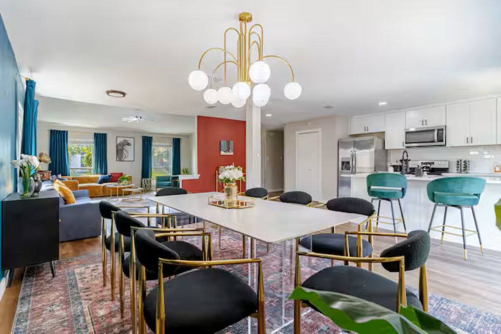 Una sala moderna con comedor, cocina y una pared de acento roja.