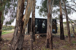 Un chalet isolé, entouré d’eucalyptus, auquel on accède par un sentier de terre.
