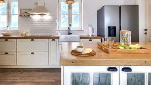 A modern kitchen with white cabinets, a wooden countertop, a built-in oven, and a window providing natural light. - Ardiletta by Interhome (Poreč/Baderna)