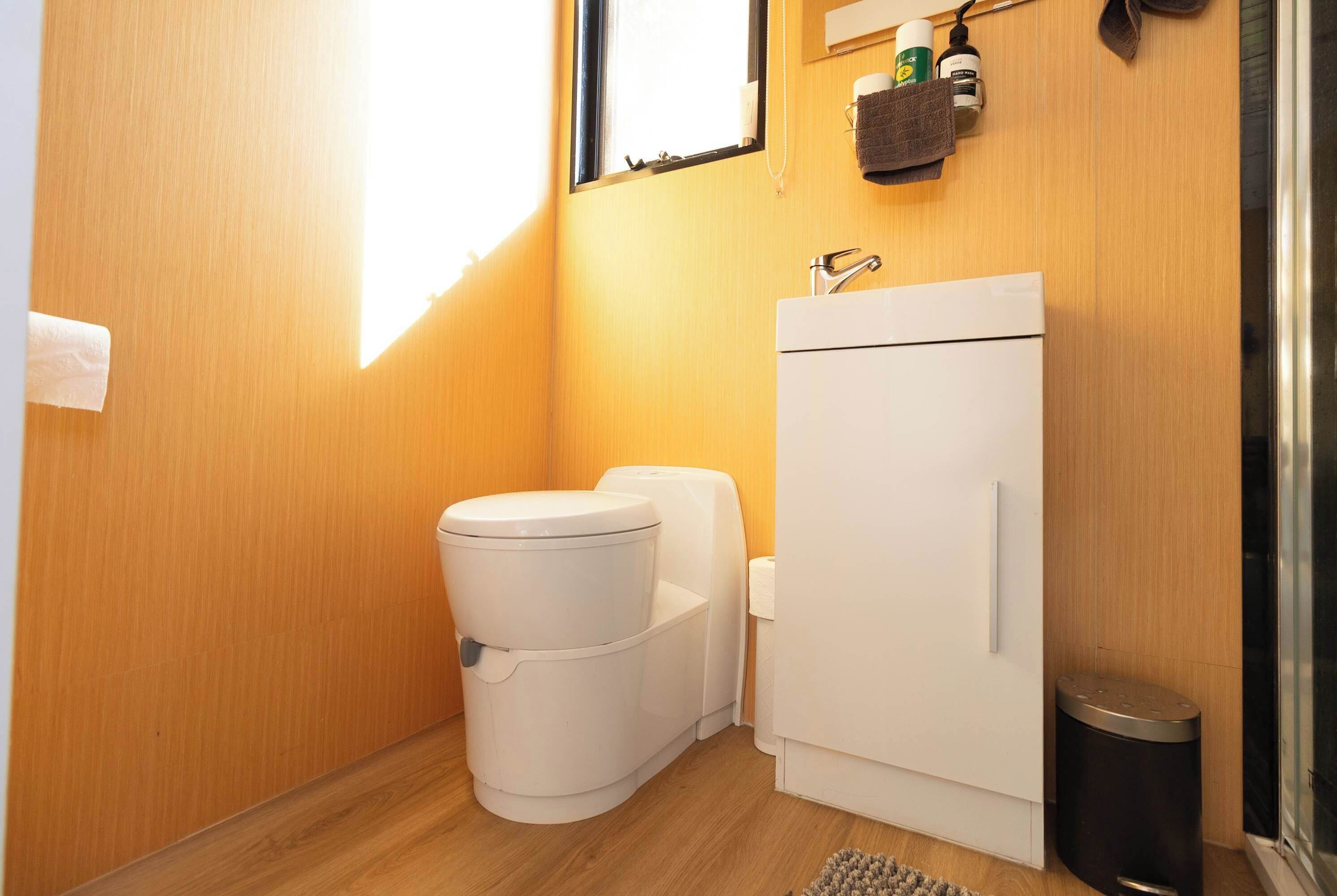 A compact bathroom with a toilet, sink, and cabinet.