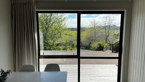 A room with a sliding glass door leading to an outdoor patio area. - Tranquil retreat in close proximity to Auckland (Ararimu)