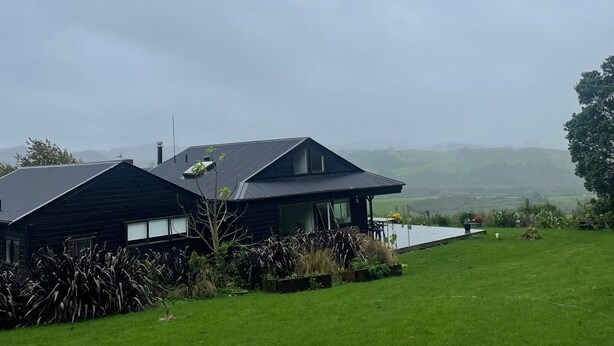 A modern house with a large lawn and a view of the countryside. - Tranquil retreat in close proximity to Auckland (Ararimu)