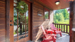 A wooden cabin with a porch, two red Adirondack chairs, a welcome sign, and a number "D3" on the door. - Mountain Retreat - walk to Main Street (Lake Placid)