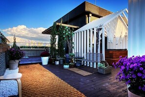 A rooftop patio with a wooden deck, a white pergola, and potted plants. - Garden Pool Villa (Seoul)