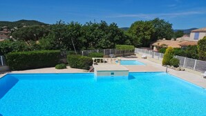 A rectangular swimming pool with clear blue water, surrounded by a tiled deck and a white fence. - Les Mas de Cogolin by Interhome (Cogolin)