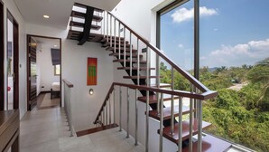 A modern staircase with metal railings and wooden steps, leading to a balcony with a view of greenery and hills. - Modern 3BR Pool Access Villa Argent 6 (Thep Krasattri)