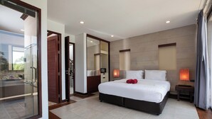 A modern hotel room with a large bed, a glass door leading to a balcony, a small bedside table with a lamp, and a view of the outdoors. - Modern 3BR Pool Access Villa Argent 6 (Thep Krasattri)