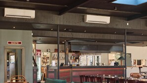 A bar area with a red carpet, wooden furniture, and a 'Gents' sign. - Alpine Inn (Khancoban)