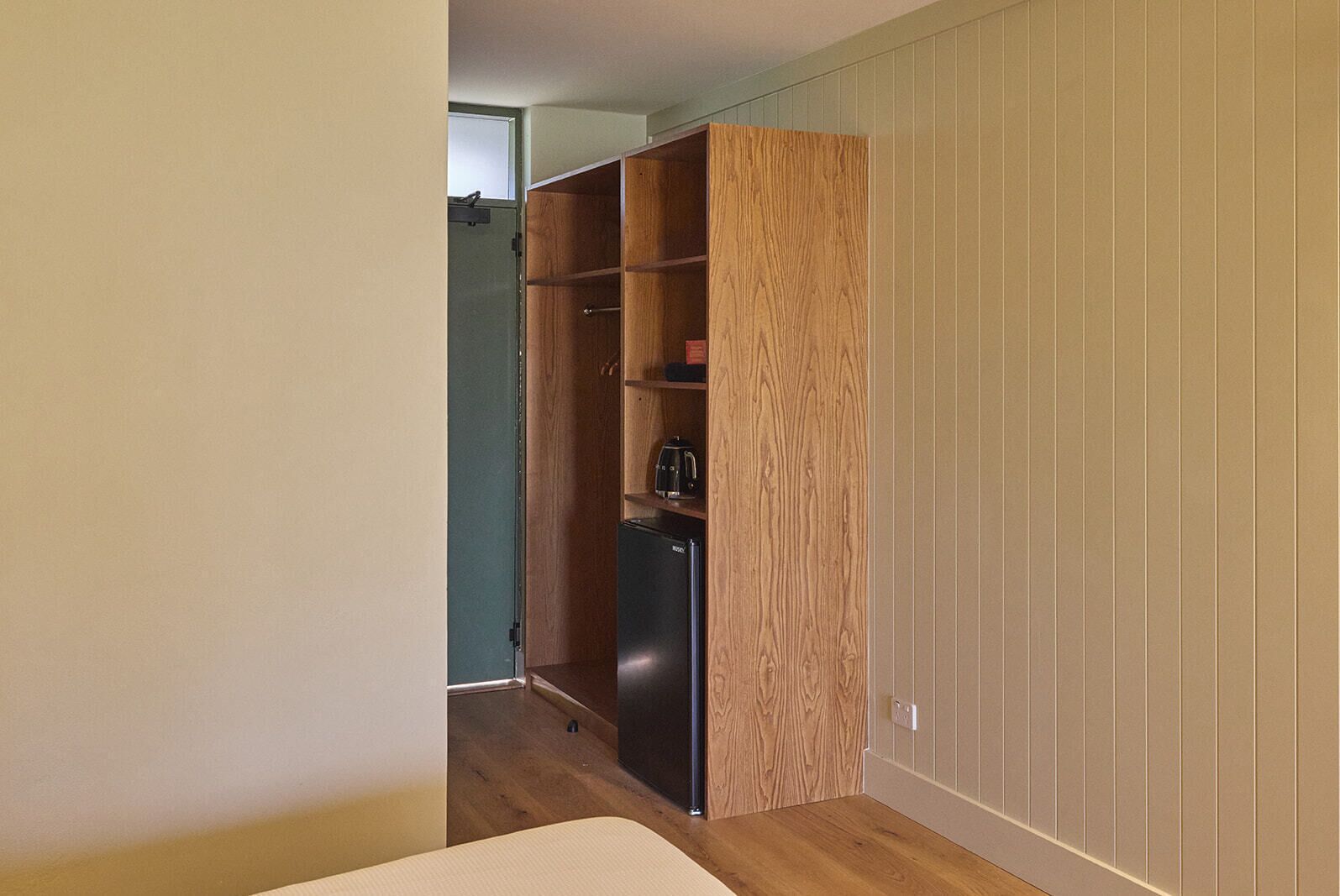 A compact kitchen with a built-in refrigerator and wooden cabinets.
