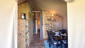 Un intérieur chaleureux, avec des éléments en bois, comprenant un coin repas, une cuisine et un couloir.
