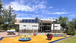 Une aire de jeux avec une structure d’escalade, une fosse à balles et un trampoline.