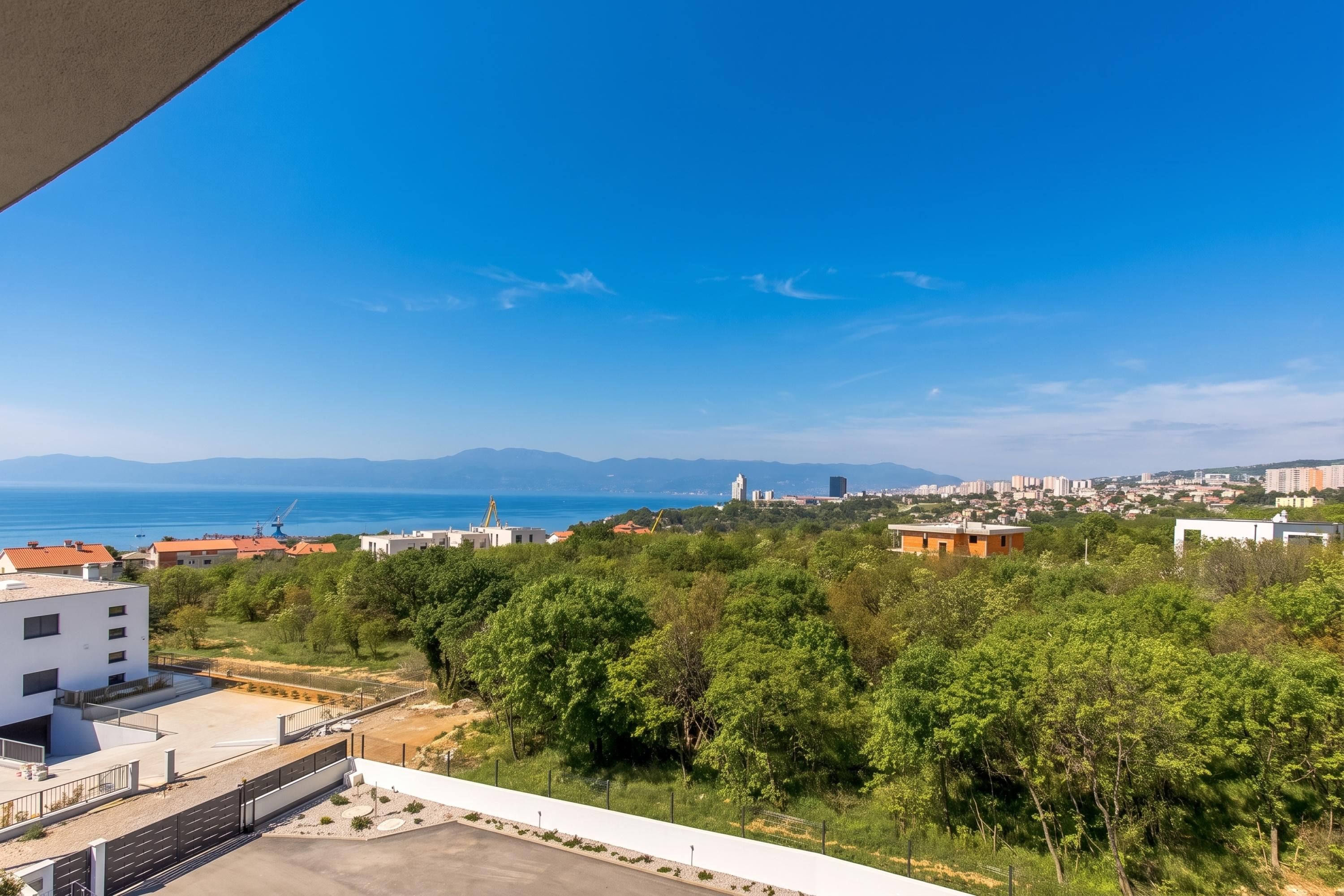 A residential area with a view of the sea and distant mountains.