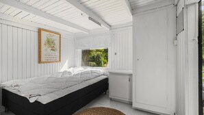 A bedroom with a bed, a window, a wardrobe, and a framed picture on the wall. - 4 bedroom amazing home in Martofte (Martofte)