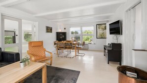 A spacious living area with a dining set, a television, and a fireplace. - 4 bedroom amazing home in Martofte (Martofte)