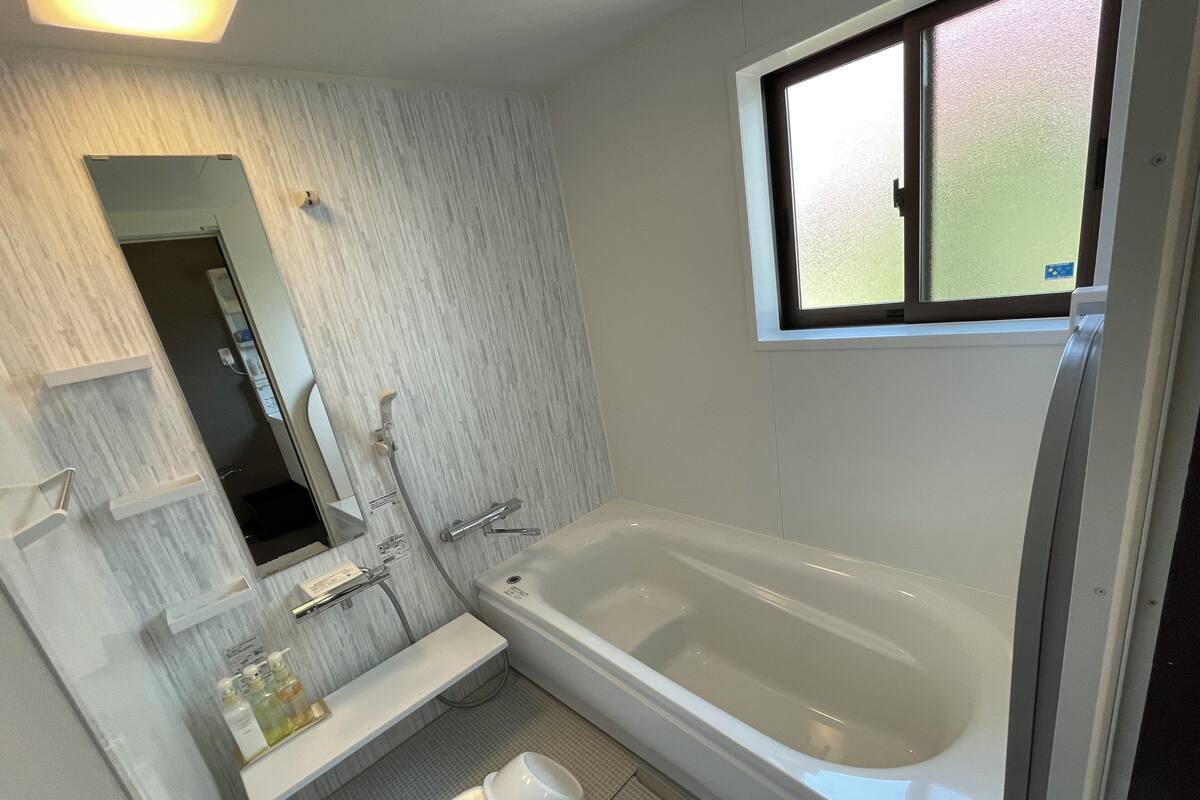 A modern bathroom with a bathtub, toilet, and sink.