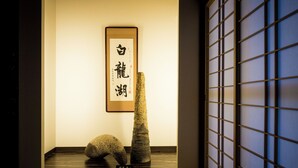Une pièce de style japonais traditionnel, avec un sol recouvert de tatamis, un paravent shoji et des calligraphies murales.
