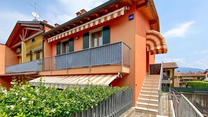 A two-story building with a balcony, a satellite dish, and a staircase leading to the entrance. - Stunning apartment in Albarè di Costermano with WiFi (Albarè di Costermano)