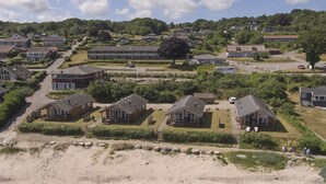 Een kustgebied met huizen, een zandstrand en een weg.