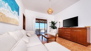 A living room with a sofa, a coffee table, a TV, and a wooden cabinet. - Lanzarote Paradise - Pool, AACC and BBQ By LVH (Playa Blanca)